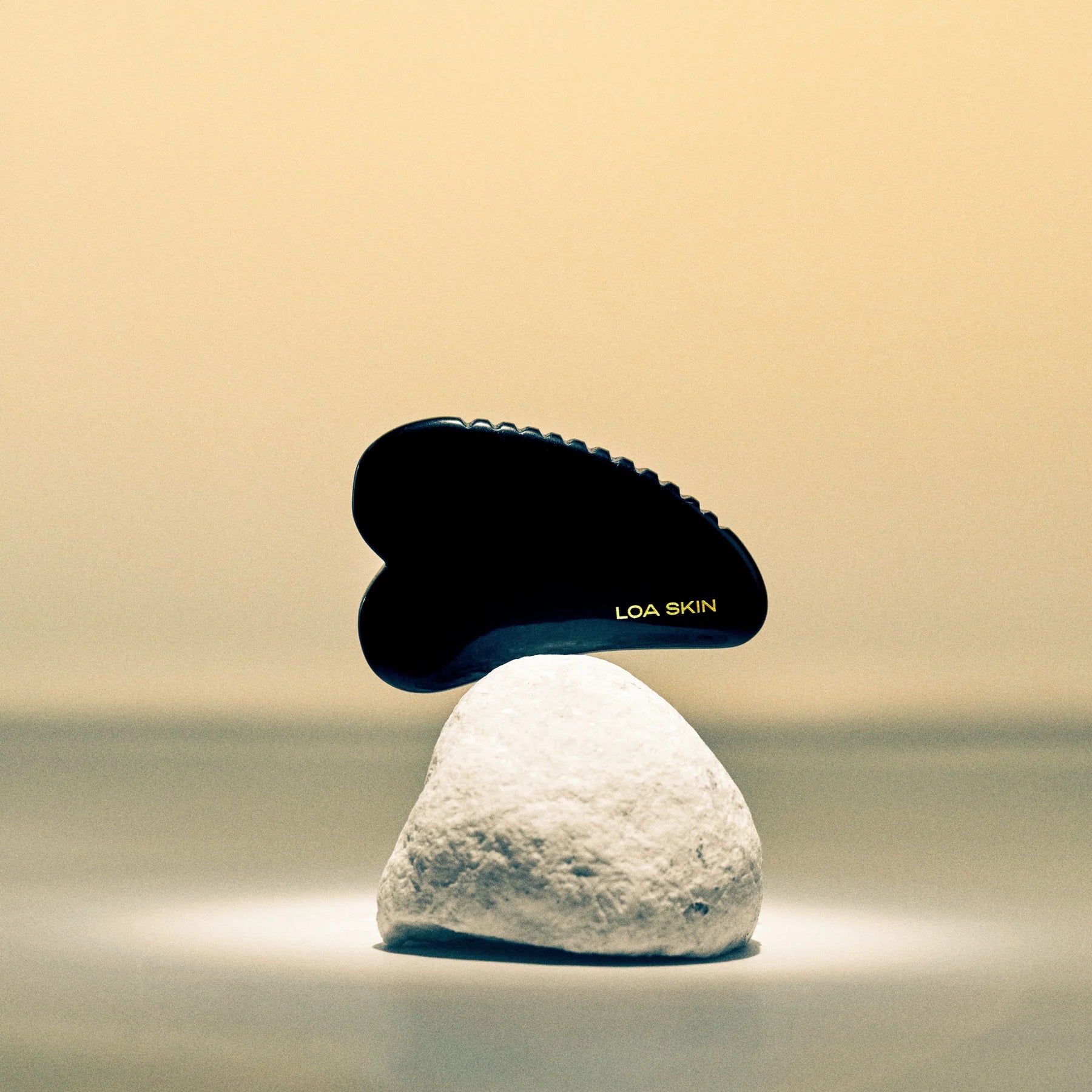 an obsidian facial massage tool that has a lifting, tightening, and de-puffing effect on the skin. Its ribbed side allows for a deeper targeted treatment.