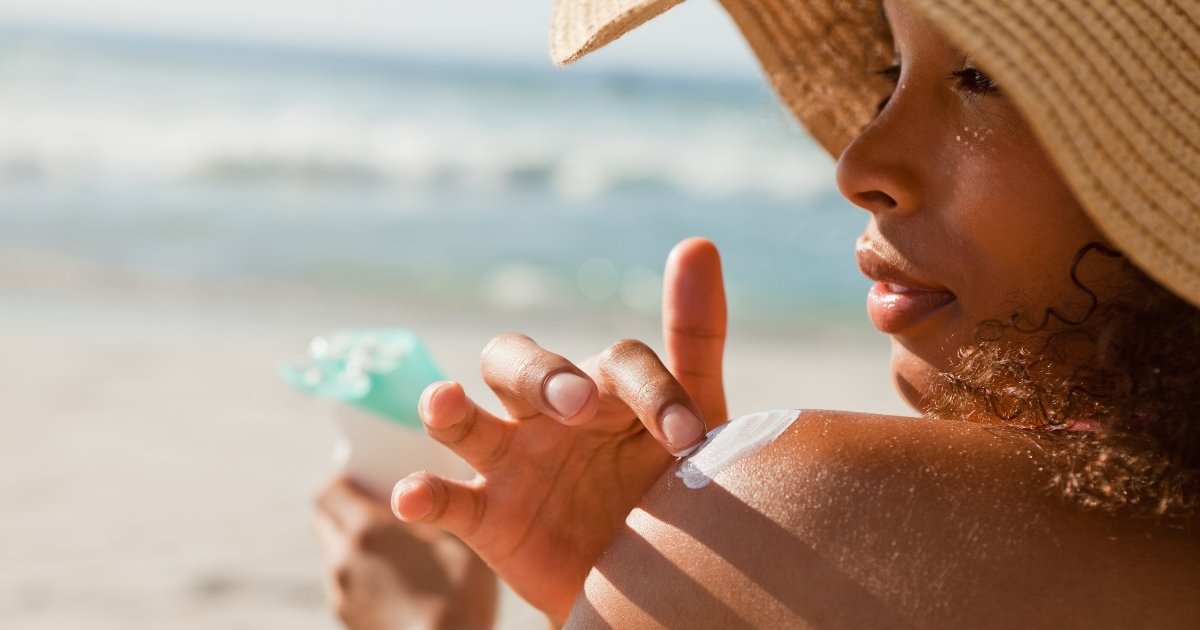 Woman applying natural mineral sunscreen to her shoulder