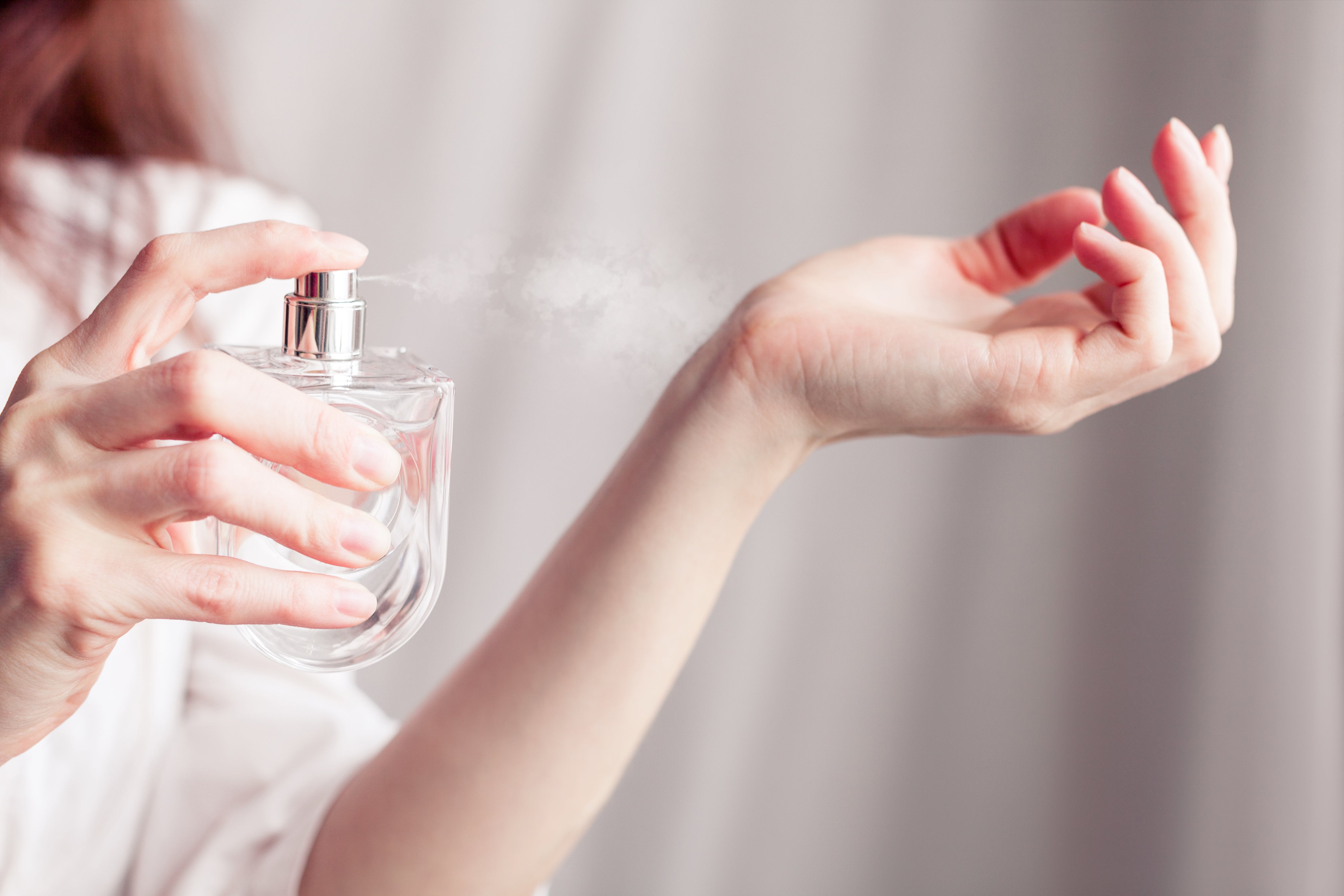 Woman spritzes natural perfume on her wrist 