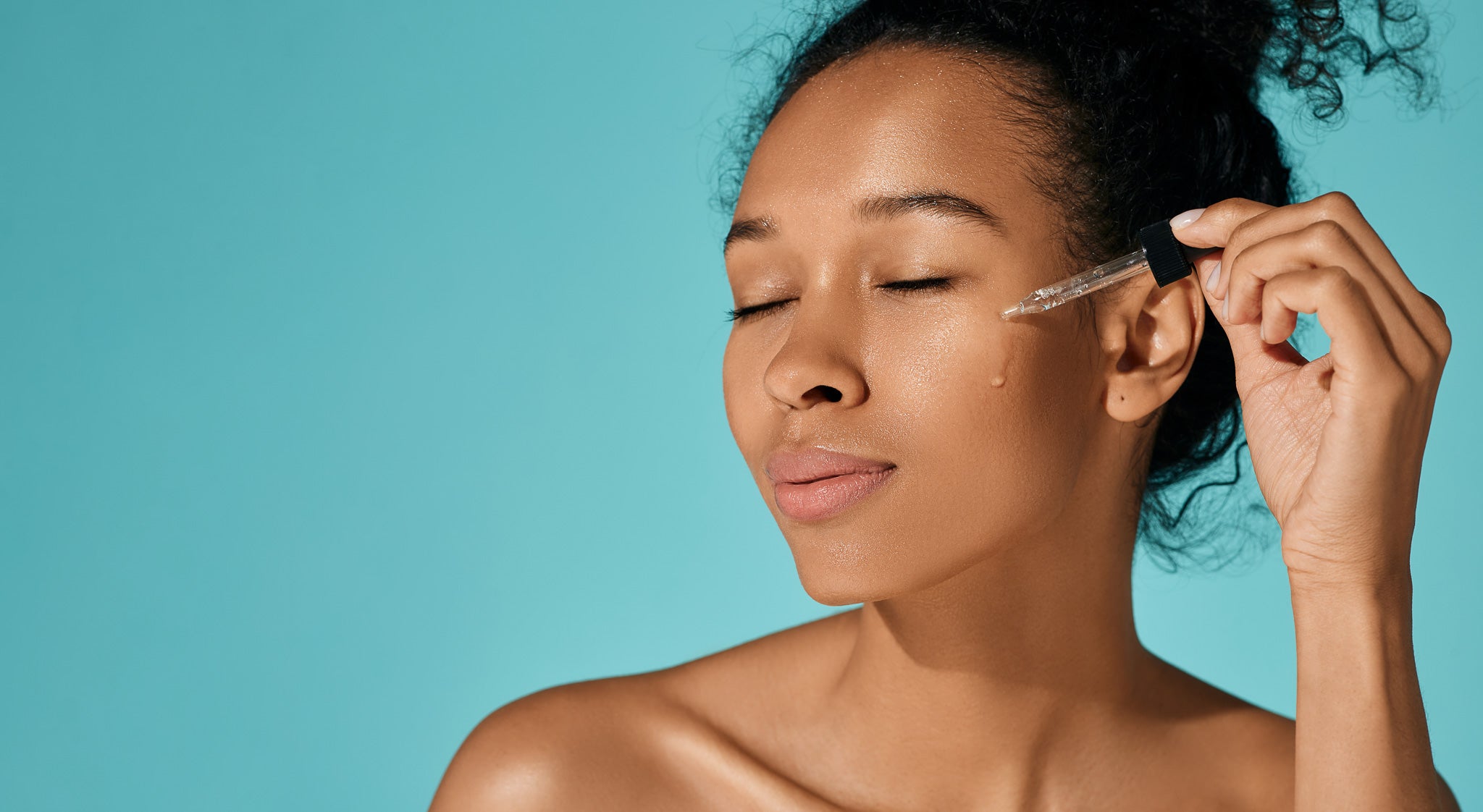 Woman applying an all natural non toxic skincare oil to her face, sold at The Green Kiss