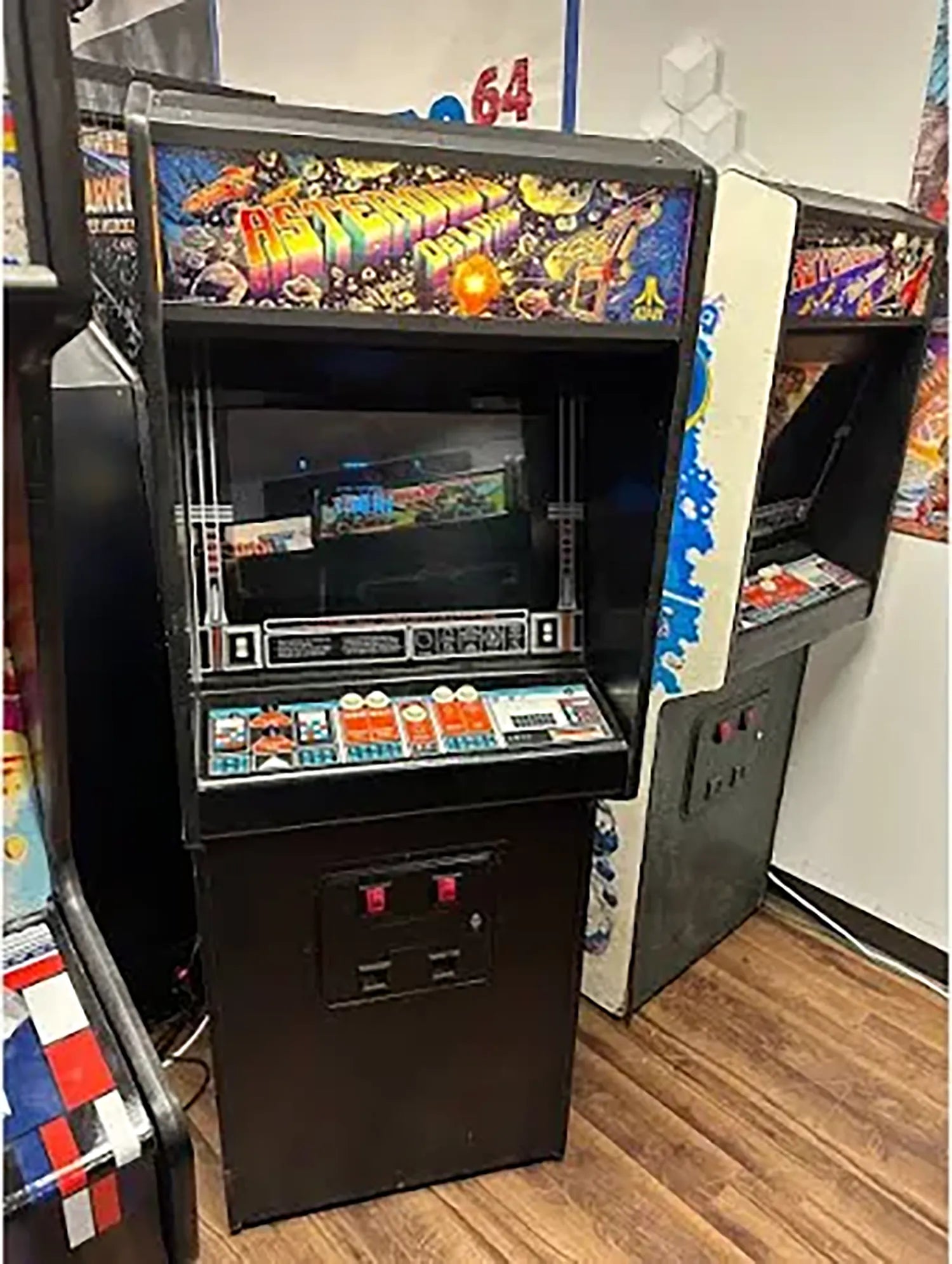 A classic Asteroids Deluxe arcade game between other arcade games in a game room