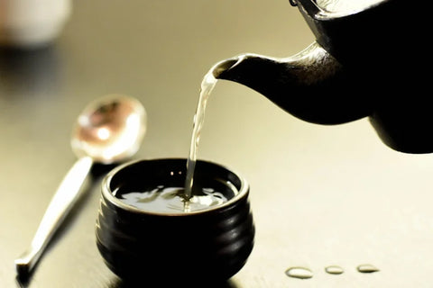 Théière qui verse de l'eau dans une tasse.