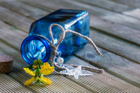 A yellow flower in a blue bottle