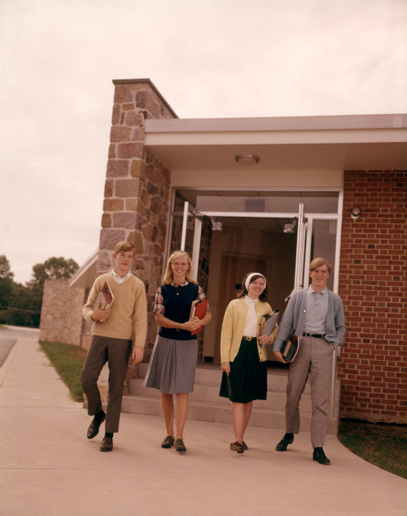 1960s Four Teenage Students Walking Out Of Suburban High School