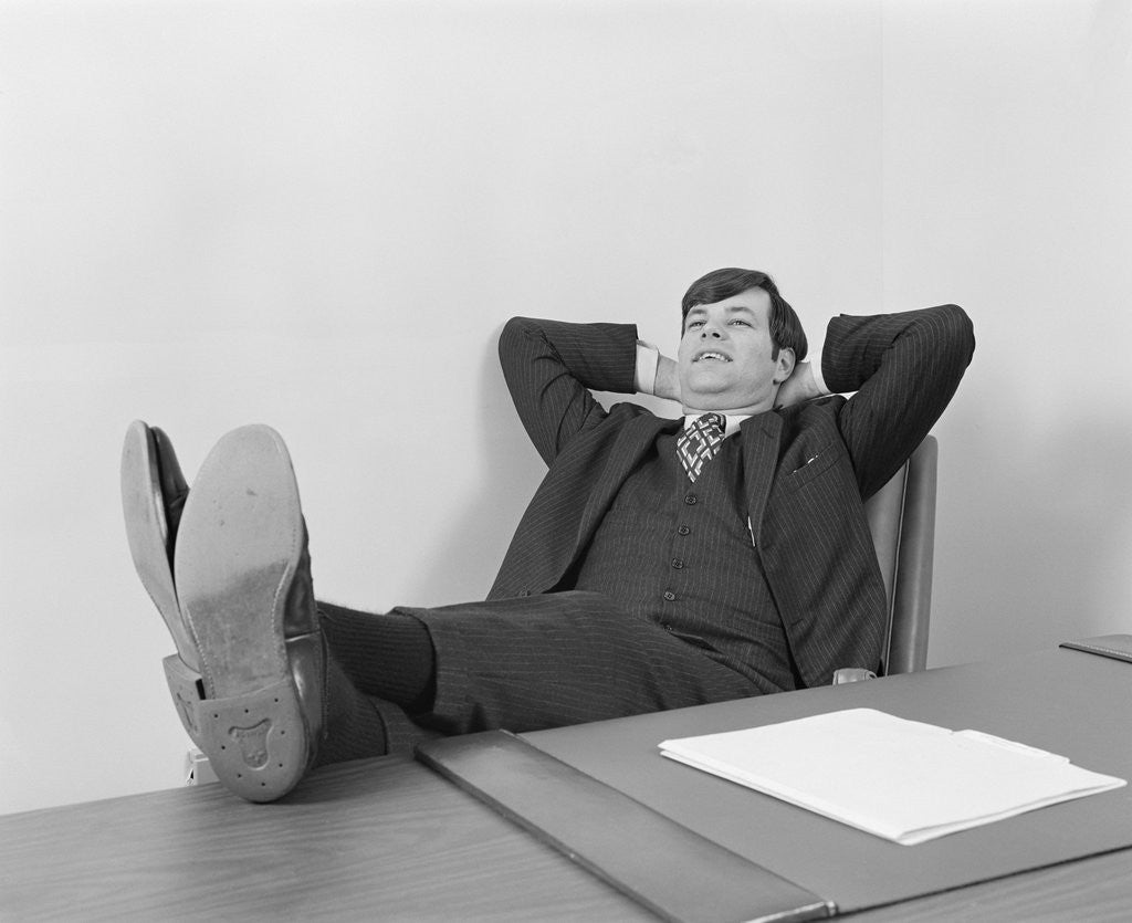 Confident Young Businessman Sitting Relaxed With Feet Up On D