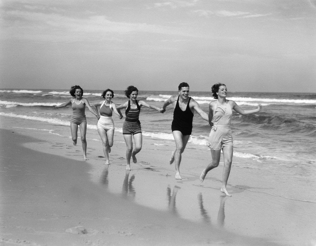 1930s four women and one man running on beach holding hands posters ...