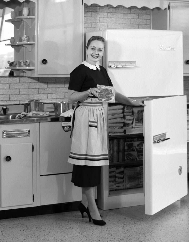 1950s smiling woman housewife in kitchen taking frozen food out of  refrigerator freezer posters &amp; prints by Corbis
