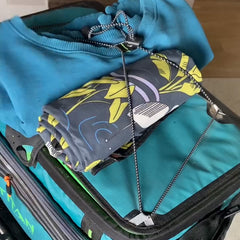 A sweatshirt and towel neatly packed on top of a cooler bag