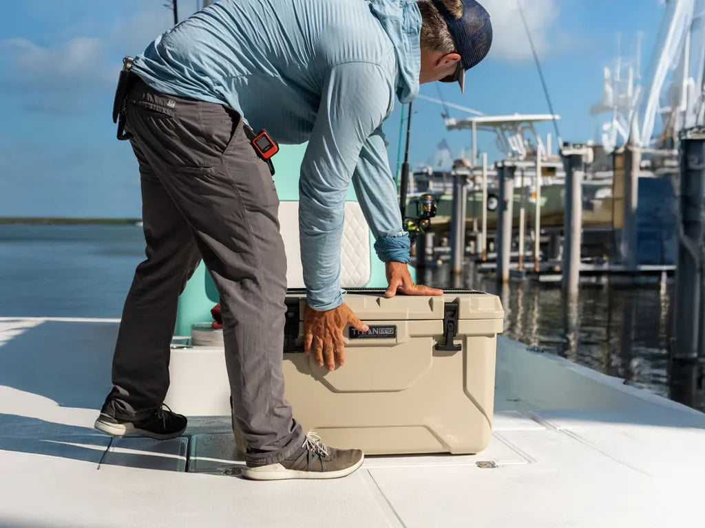 Guy on a boat closing the latch on his Titan PRO hard cooler