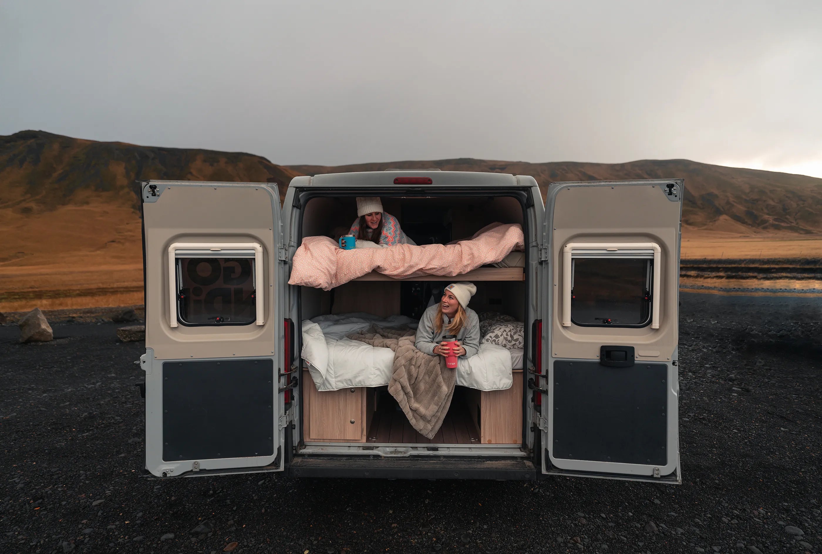 Two girls with Titan Drinkware sitting in a camper van while traveling