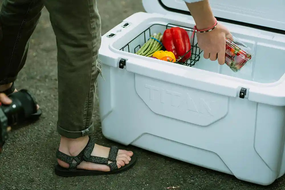 Person reaching into a Titan Hard Cooler for food