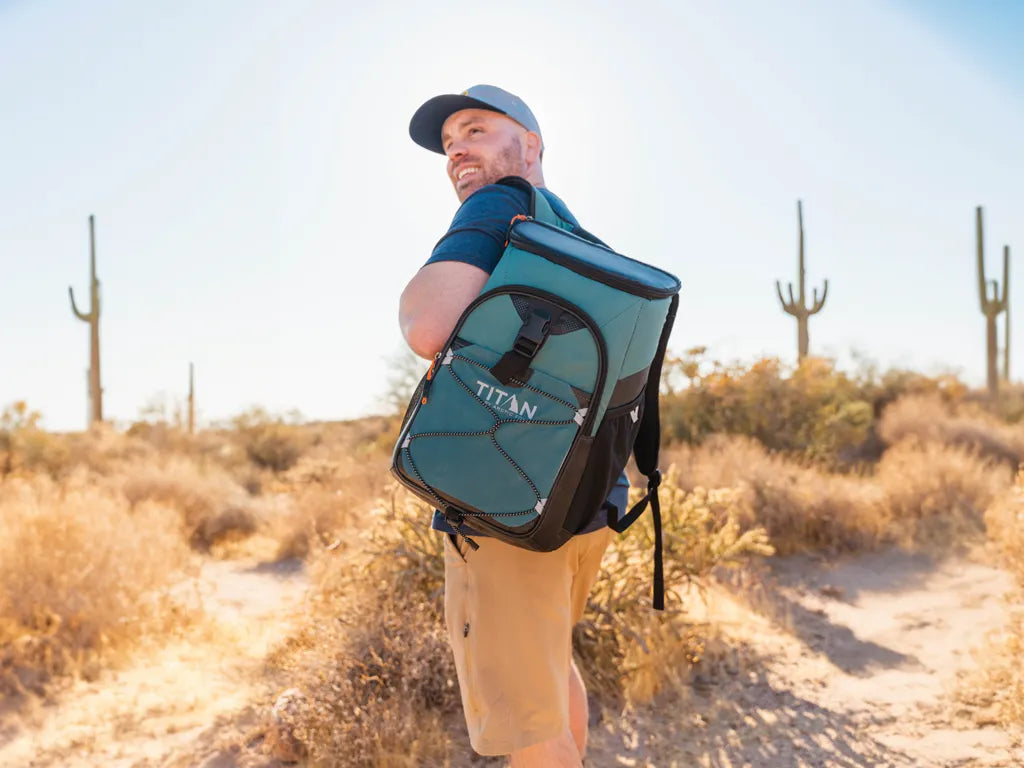 A man wearing a Titan backpack cooler while hiking