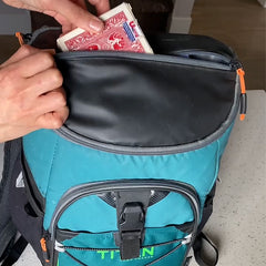 Person packing a box of playing cards into a backpack cooler