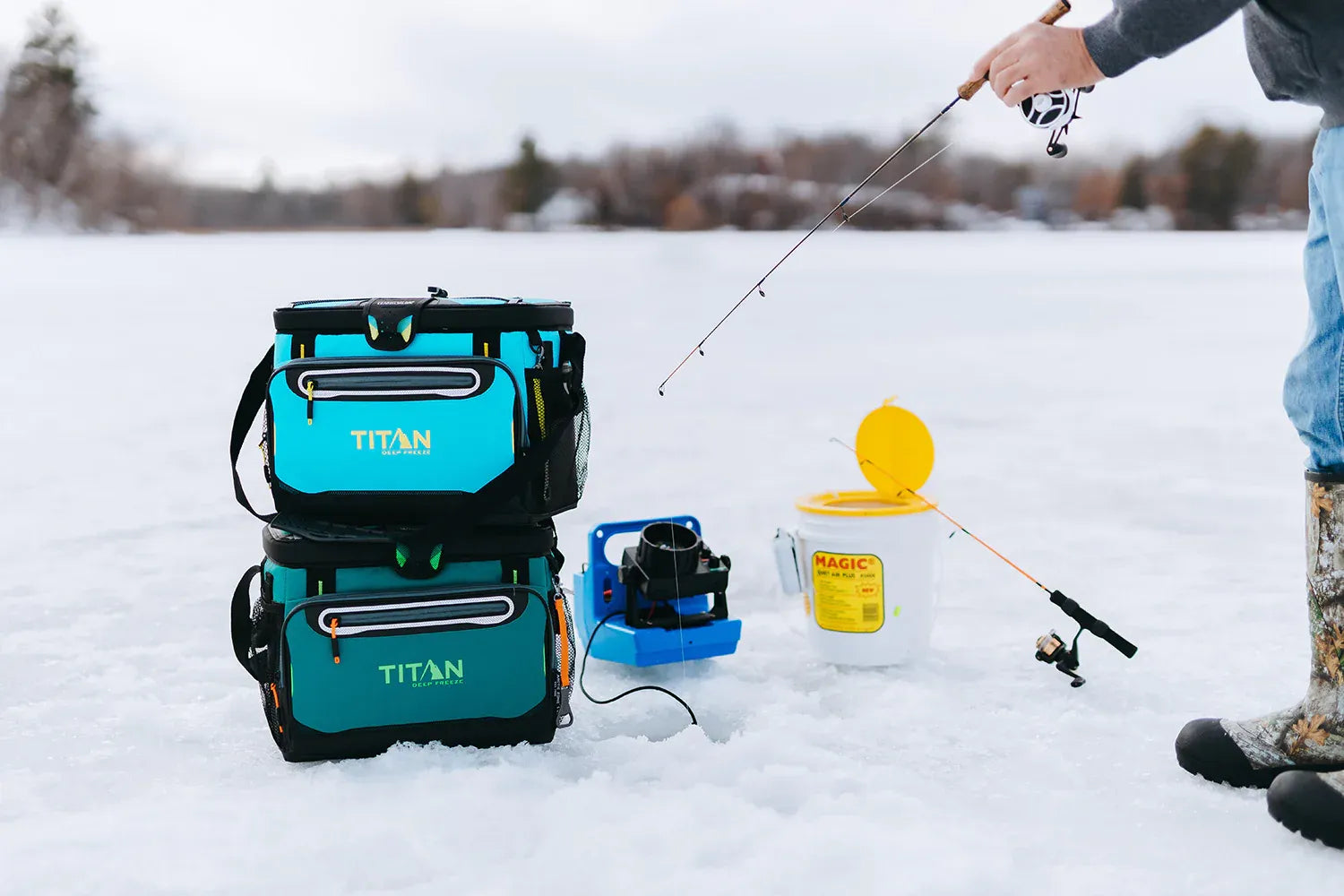 Person ice fishing with two Titan Deep Freeze® 30 Can Zipperless Hardbody® Coolers stacked close by