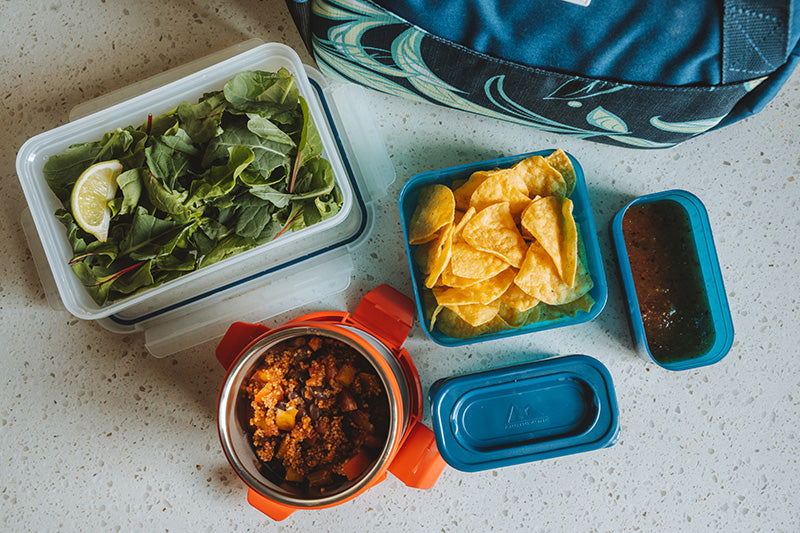 Kitchen counter with reusable food containers filled with lunch and snacks