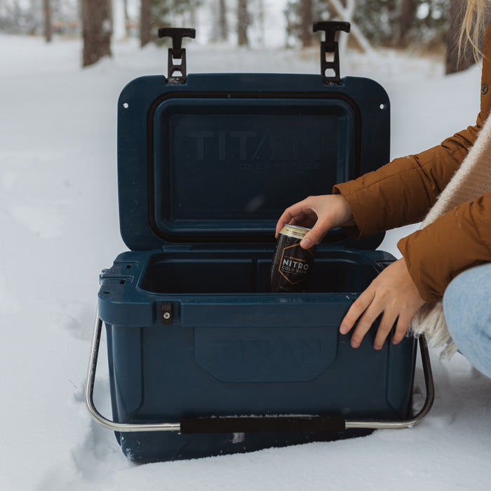 Person pulling out a can from a Titan by Arctic Zone™ 20Q High Performance Hard Cooler.