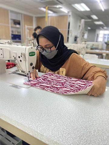 Image of an artisan at Batik Boutique sewing centre.