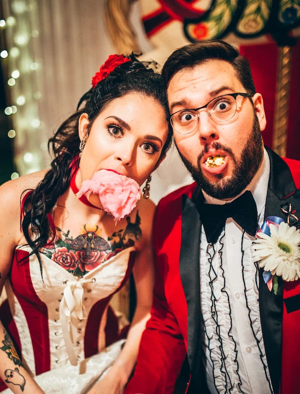 Julia and Curtis eating popcorn and candyfloss at their Greatest Showman Wedding