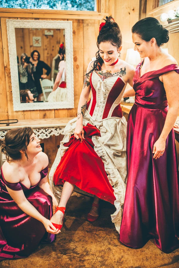 Julia and her bridesmaids showing off her red shoes that matched so well with the Gallery Serpentine red and ivory bridal gown