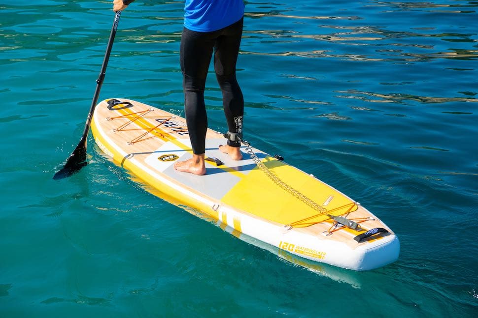closeup of man paddling on Thurso Surf Waterwalker All-around SUP with yellow stand up paddleboard traction pad