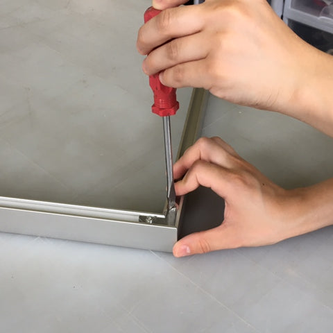 Slide an adjacent frame side onto the protruding corner plates and tighten with a screw driver. Repeat to create a U shape with three frame sides