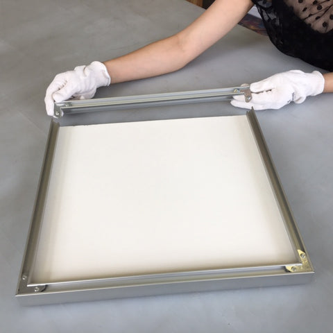 Insert corner plates at both ends of the last frame side then slide it on. Flip the frame over and ensure all the corners meet well and are tight.