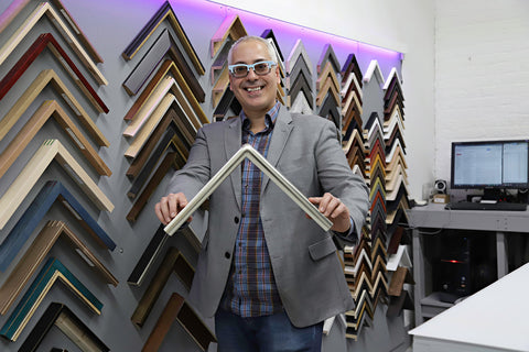Erick at Frames and Stretchers Factory in Gowanus with a hand gilded curved frame