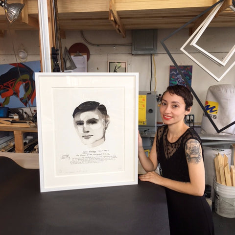 A Frames and Stretcher employee holding Marlene Dumas' portrait of Alan Turing that was floated using Japanese paper and wheat paste and custom framed at Frames and Stretchers on the Lower East Side.