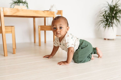 older baby crawling by table