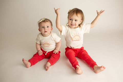 baby and toddler in finn + emma clothing: white top and red bottoms