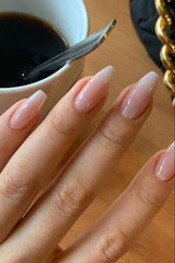 fingers with ballerina shaped nails in sheer pink polish