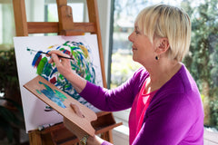 middle aged woman abstract painting with easel and brush | hobbies