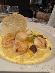 Roasted scallops with pumpkin risotto and decorative wafer cracker meal at bistro in Paris