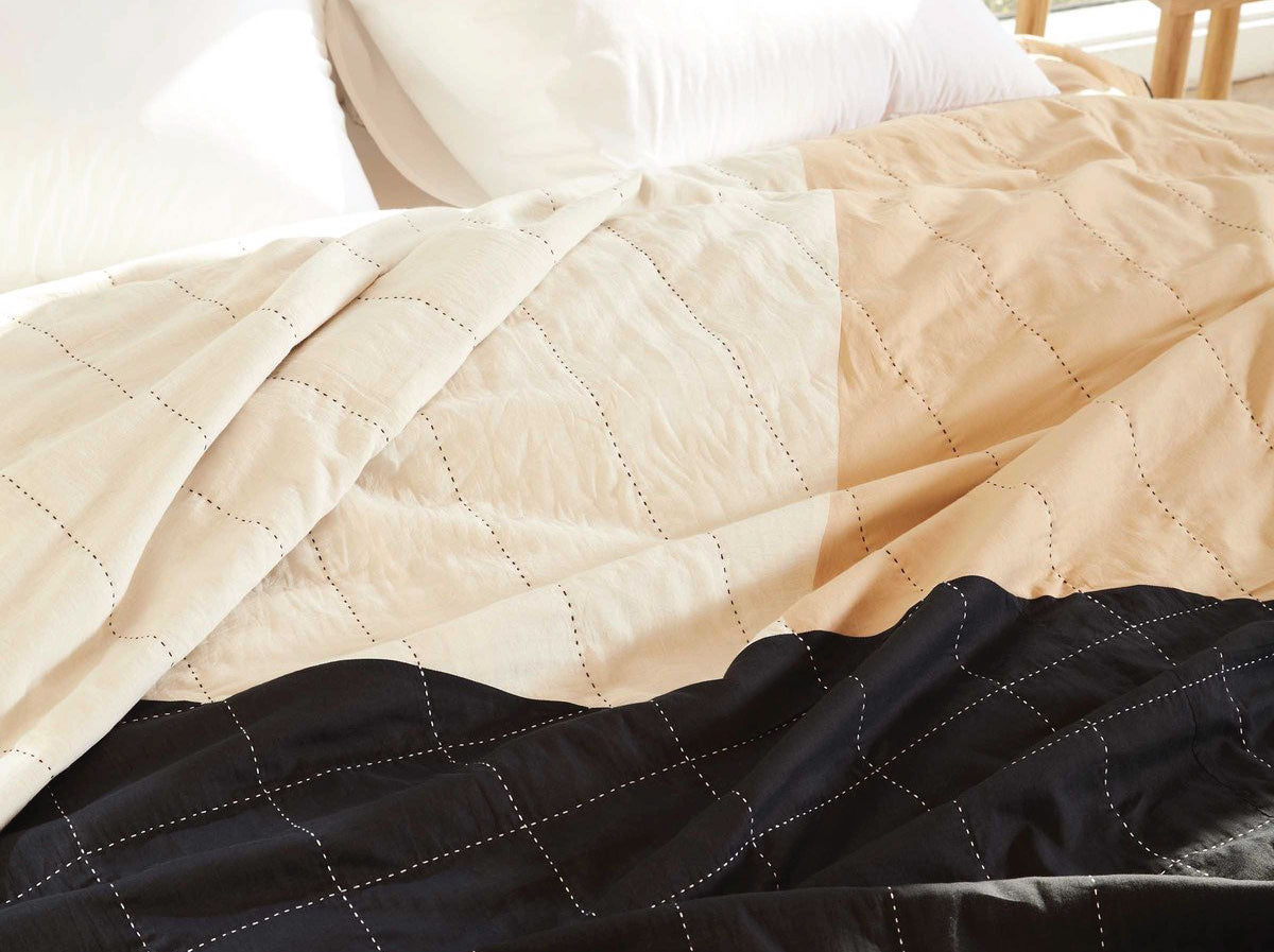 Close up view of Anchal x Brooklinen bedding in tan, black and cream