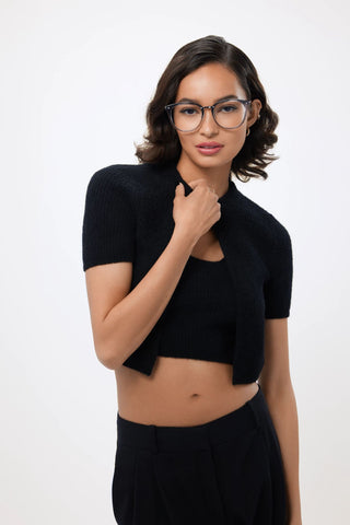 Woman in black top and pants wearing QUAY glasses