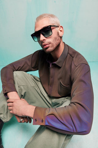 Hip man with a platinum buzzcut and brown dress shirt wearing QUAY NIGHTFALL shield sunglasses