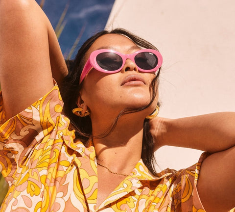 A female model posing and wearing a festival outfit with QUAY SHOW UP pink sunnies