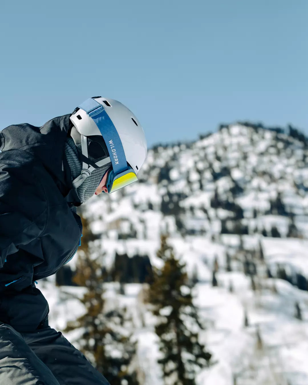 man looking down on the mountain while wearing a highline ski helmet