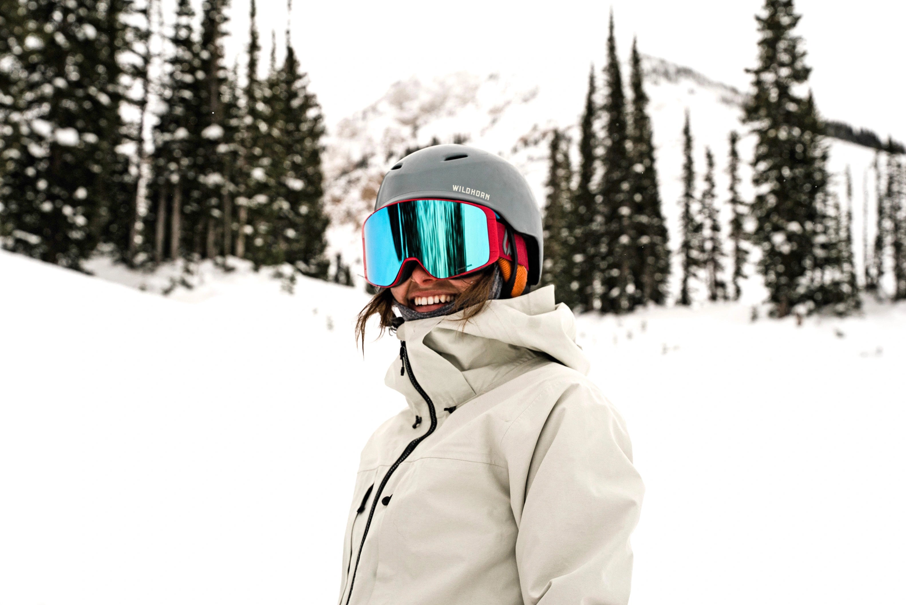 woman smiles while wearing a Wildhorn snow helmet