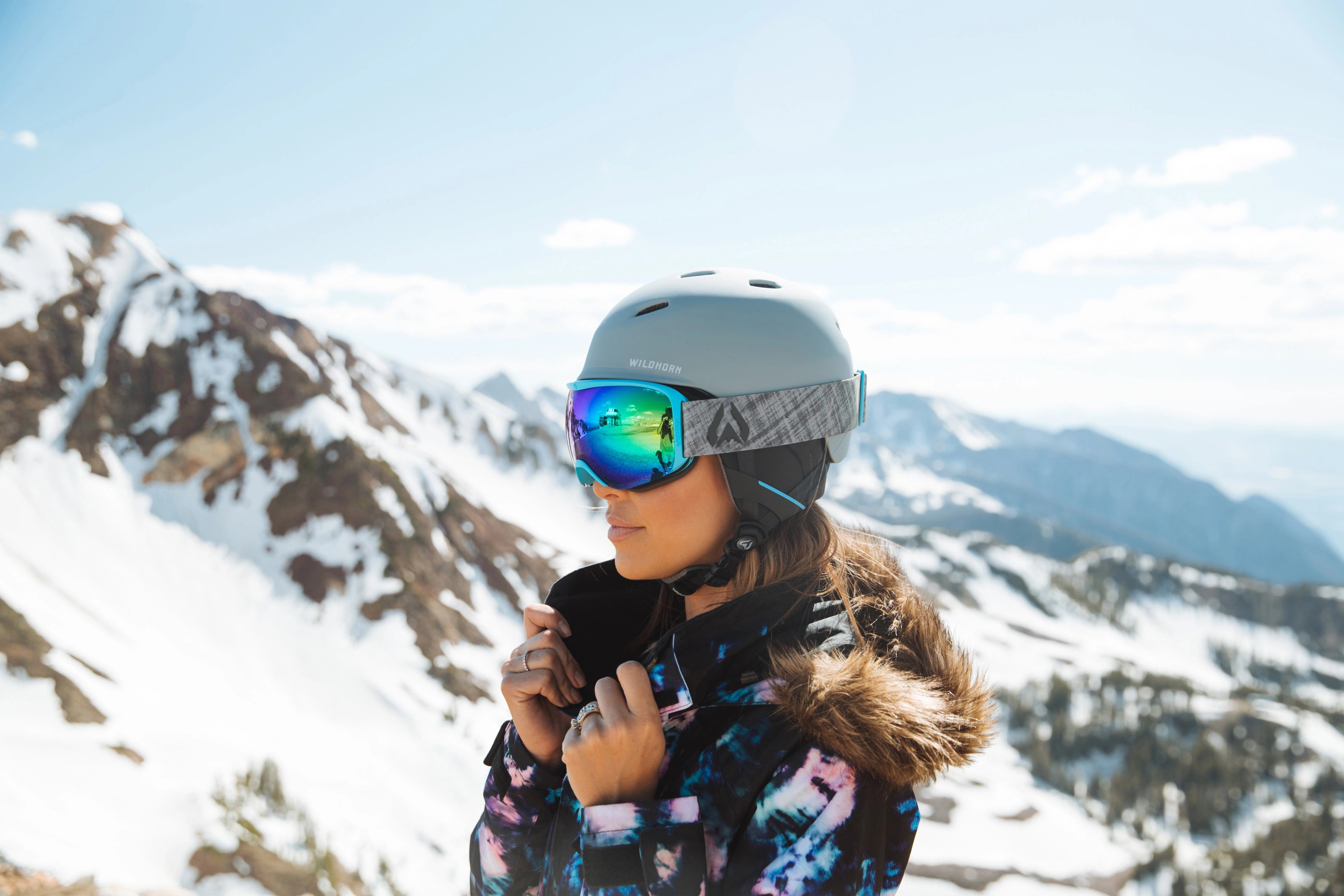 woman looking off into the distance through ski goggles in snow gear on a mountain