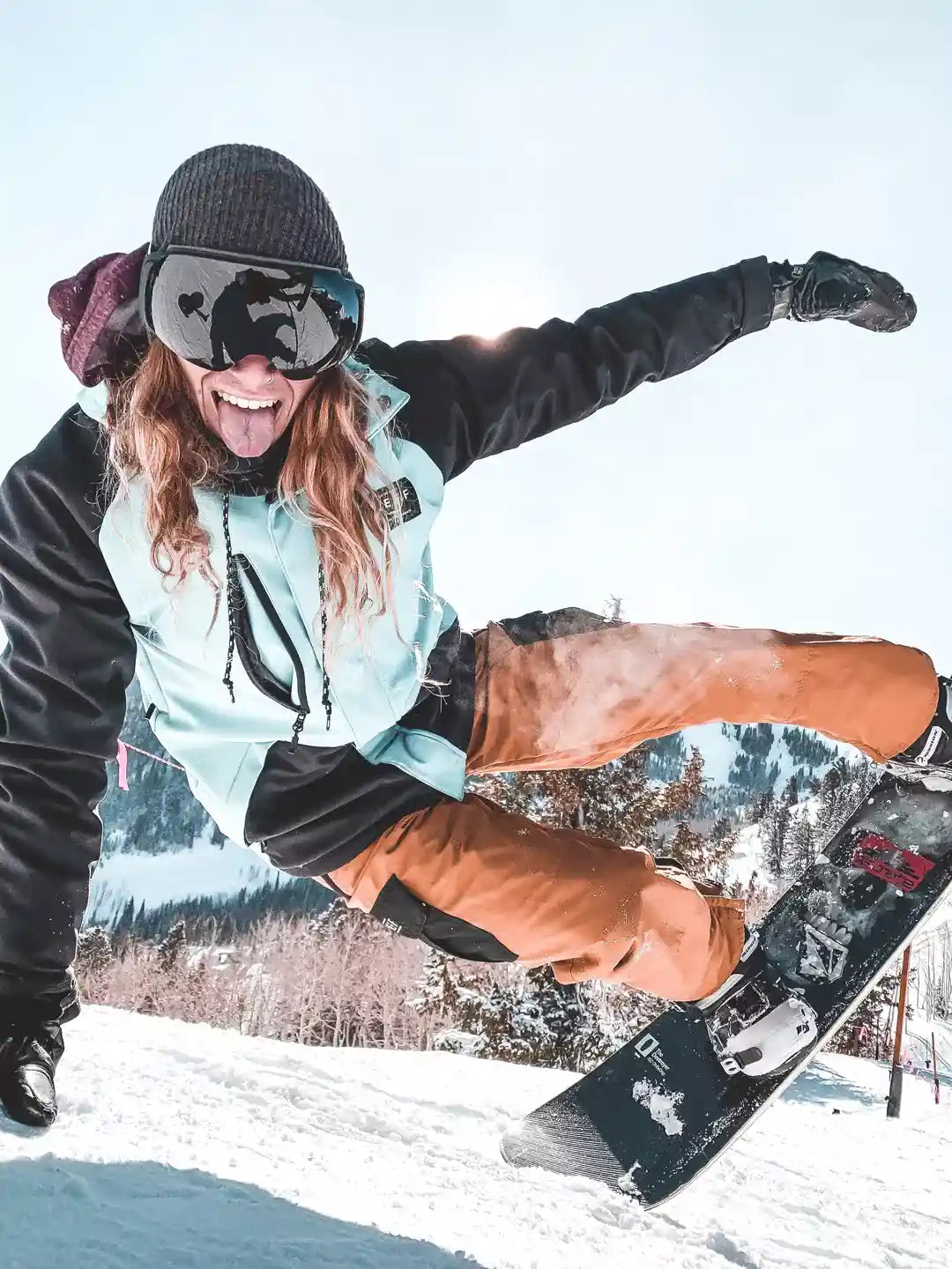 snowboarder goofing around while snowboarding and wearing roca ski goggles