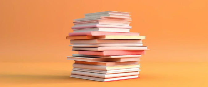 กองหนังสือวางอยู่บนพื้นหลังสีเหลือง ประกอบบทความเกี่ยวกับแบบฟอร์มแผนธุรกิจ