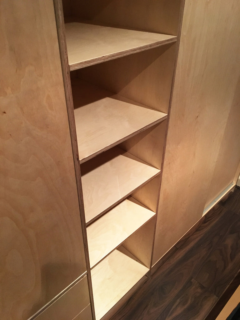 Bespoke plywood shelving unit as part of the wardrobe.