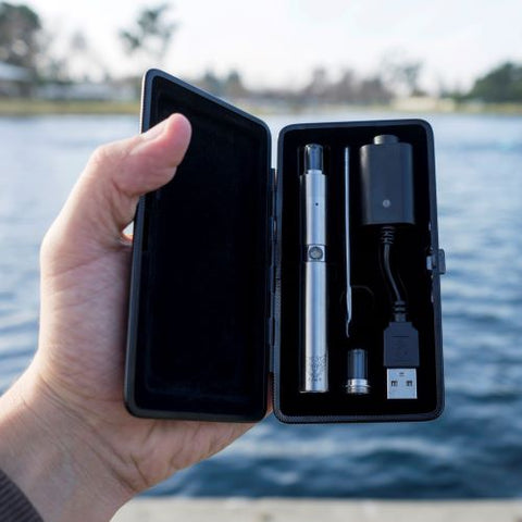 Linx Hypnos Zero Wax Pen in portable carrying case held in front of a body of water