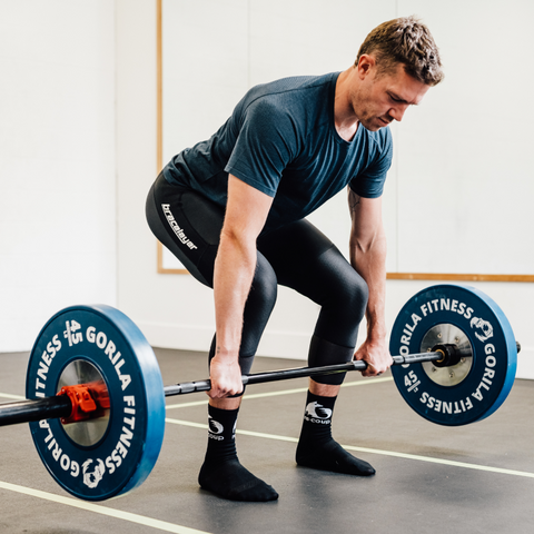A person doing a deadlift with a barbell. Deadlifts are also an essential exercise from this list of quad strengthening exercises for bad knees, but should not be the first exercise sore knees are exposed to.