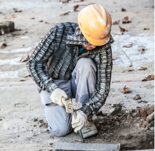 A construction worker breaking up concrete. Construction and other manual labour trades can cause a lot of knee pain.