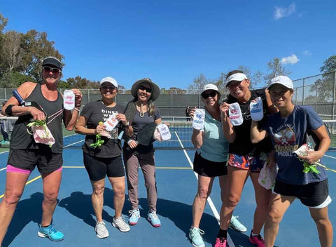 Pickleball team has fun and holds up matching pickleball-themed socks