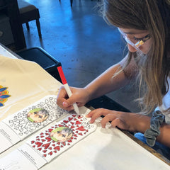 This is an image of a girl coloring in the Custom Coloring Book Socks.
