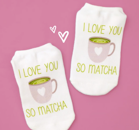 Cute socks with a cup of green tea on them that say "I love you so matcha"