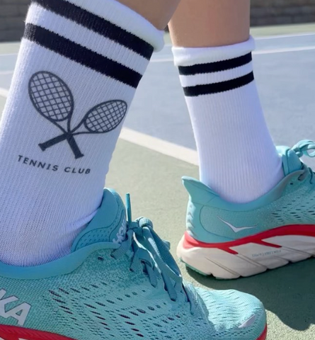 Fun tennis socks with bright shoes on a tennis court